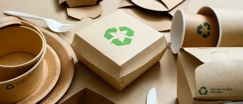 Brown paper food containers and cups printed with green recycle icons