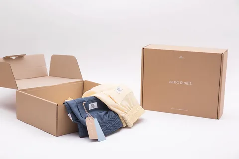 Kraft mailer box with branded design and folded clothes inside for clean apparel presentation