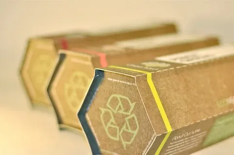 Close-up of eco-friendly hexagon cardboard tubes featuring a green recycle logo
