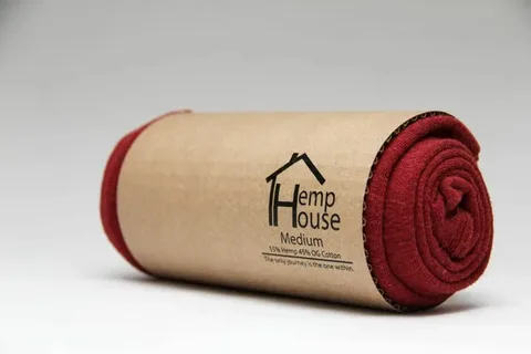Rolled red T shirt in cylindrical kraft paper packaging with printed branding
