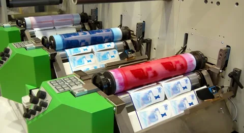 Flexographic press printing custom labels with blue and red inks on label stock