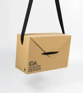 Minimalist kraft box with black ribbon handle for stylish and portable clothing packaging