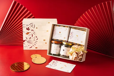 Elegant PR package with skincare jars, gift card, and accessories in a premium box on red background