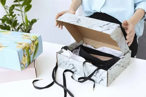 Woman opening luxury marble-printed packaging box with clothing inside