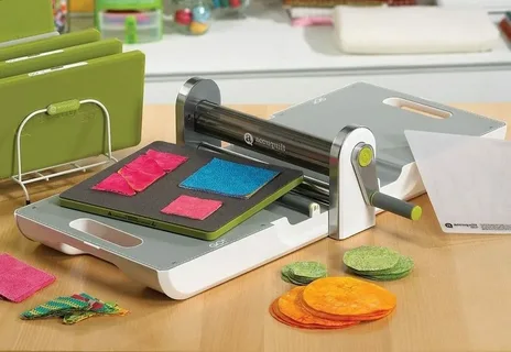 Hand crank die cutting machine with colorful fabric shapes and templates