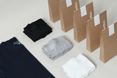 Folded underwear items with kraft paper flat pack bags labeled with white brand tags