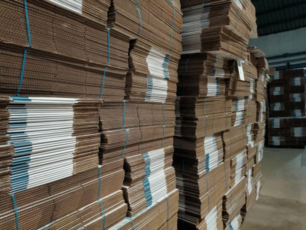 Bundles of corrugated box sheets tied with straps in warehouse