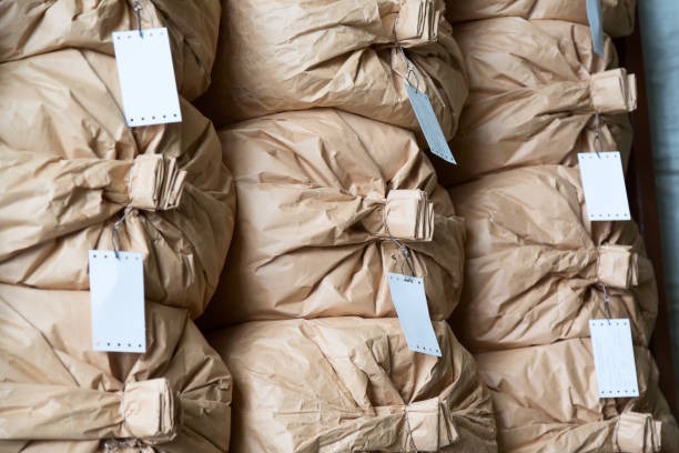 Large brown paper bags tied and tagged for bulk bagged packaged goods storage and distribution.
