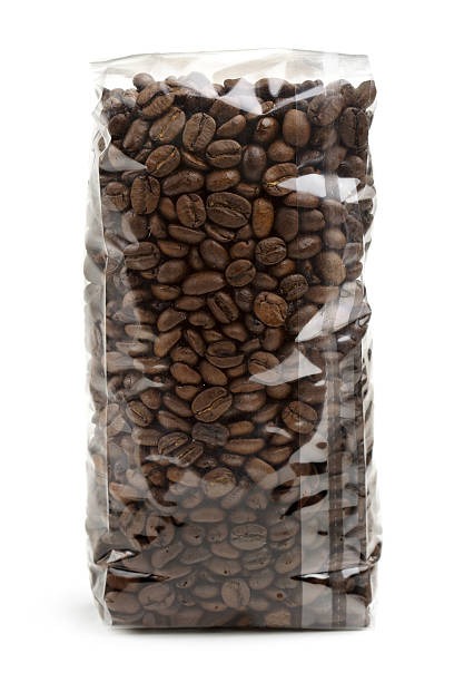 Clear plastic coffee packaging bag filled with dark roasted coffee beans.