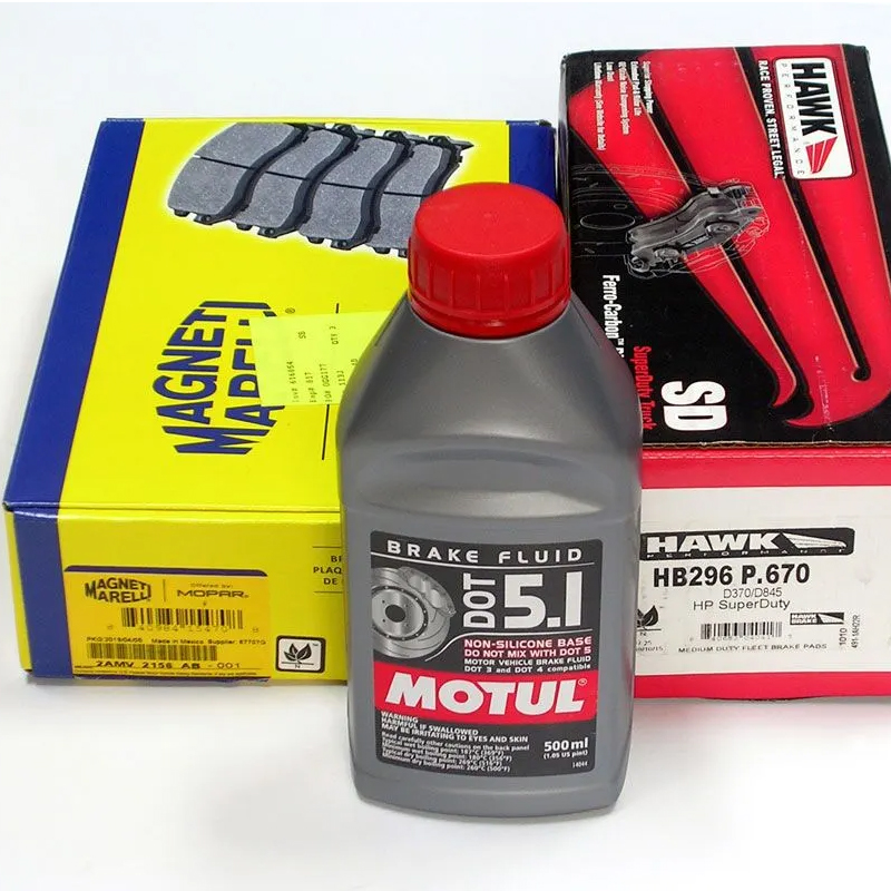 Assorted aftermarket automotive parts including MOTUL brake fluid, MAGNETI MARELLI brake pads, and HAWK brake calipers—each in branded packaging designed for retail and repair shop use.
