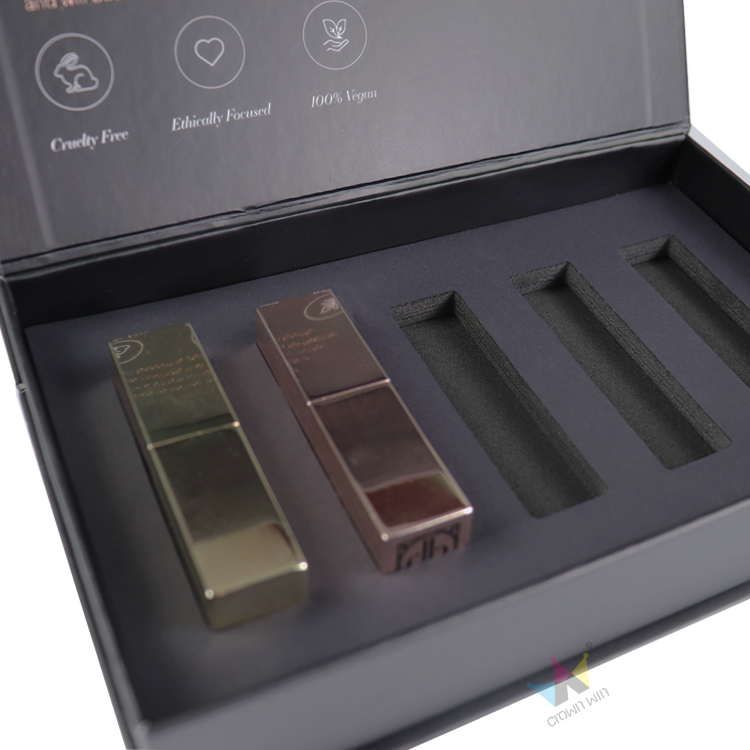 Black rigid box with precision-cut EVA foam insert holding two metallic lipsticks—demonstrating high-performance cosmetic packaging for fragile products.