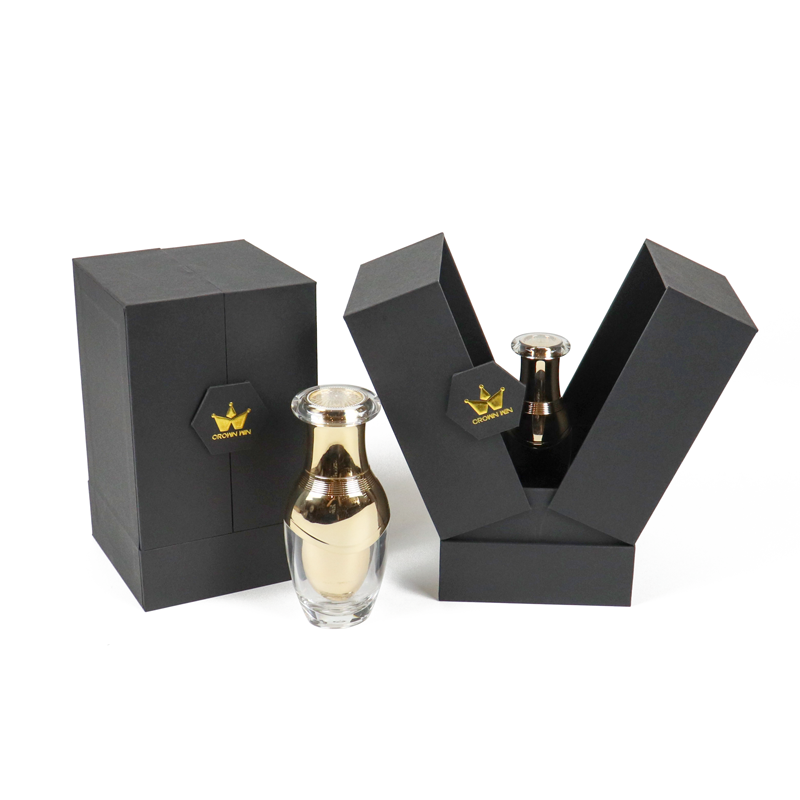 Black geometric rigid box with V-shaped opening and gold foil crown logo, housing a transparent perfume bottle with metallic finish—designed for high-end retail shelf appeal.