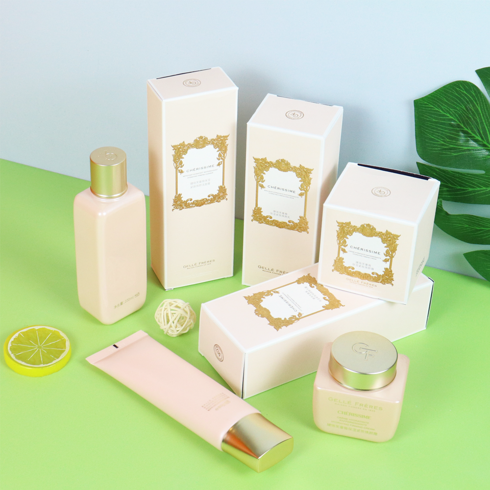 White folding cartons with gold foil decorative borders and matching skincare products in soft pink tones—demonstrating sophisticated yet cost-efficient custom cosmetic packaging.