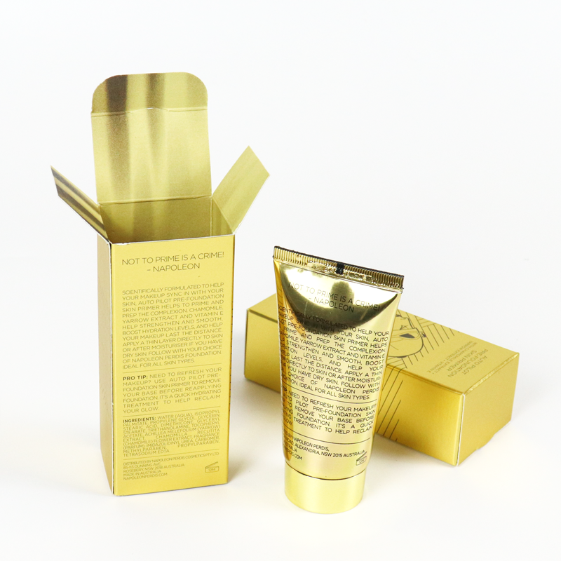 Shiny gold folding carton with printed brand messaging and matching golden tube product, showcasing how high-end finishes like foil stamping can enhance brand identity without requiring rigid box structure.