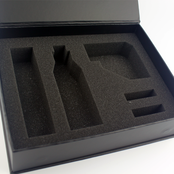 Black rigid box with soft gray sponge insert featuring custom cutouts for bottles, tubes, and accessories—demonstrating adaptable cushioning for mixed cosmetic kits.
