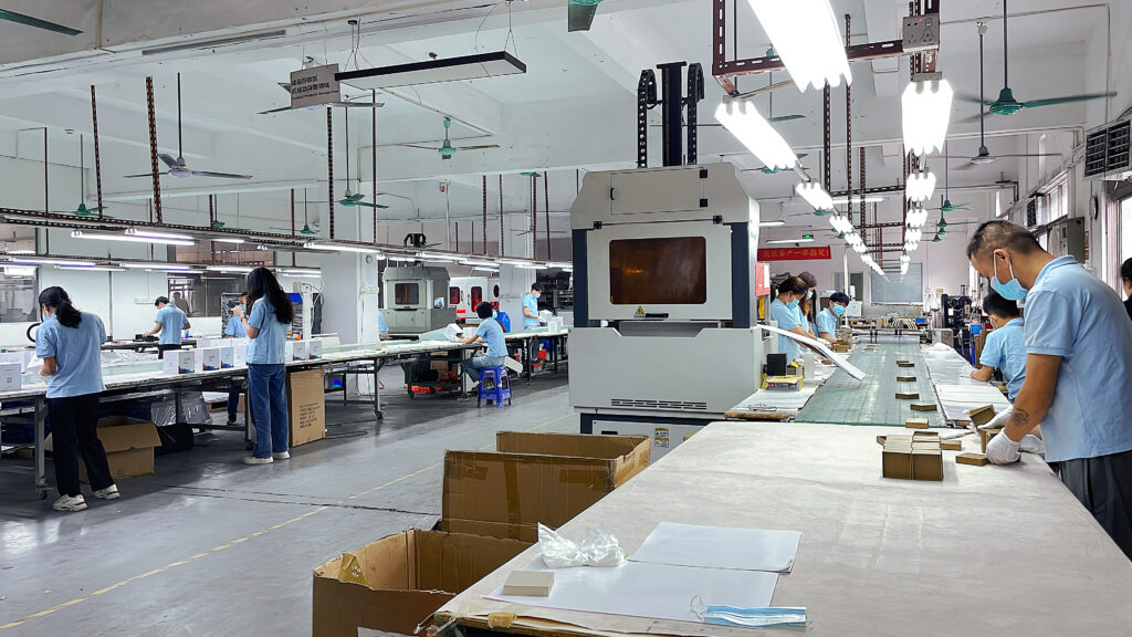 Modern factory workers assembling custom folding cartons on a production line, illustrating the manufacturing process behind scalable and cost-effective cosmetic packaging solutions.
