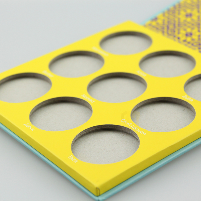 Bright yellow die-cut paperboard insert with circular cutouts for eyeshadow palette—highlighting sustainable and structural packaging without foam.