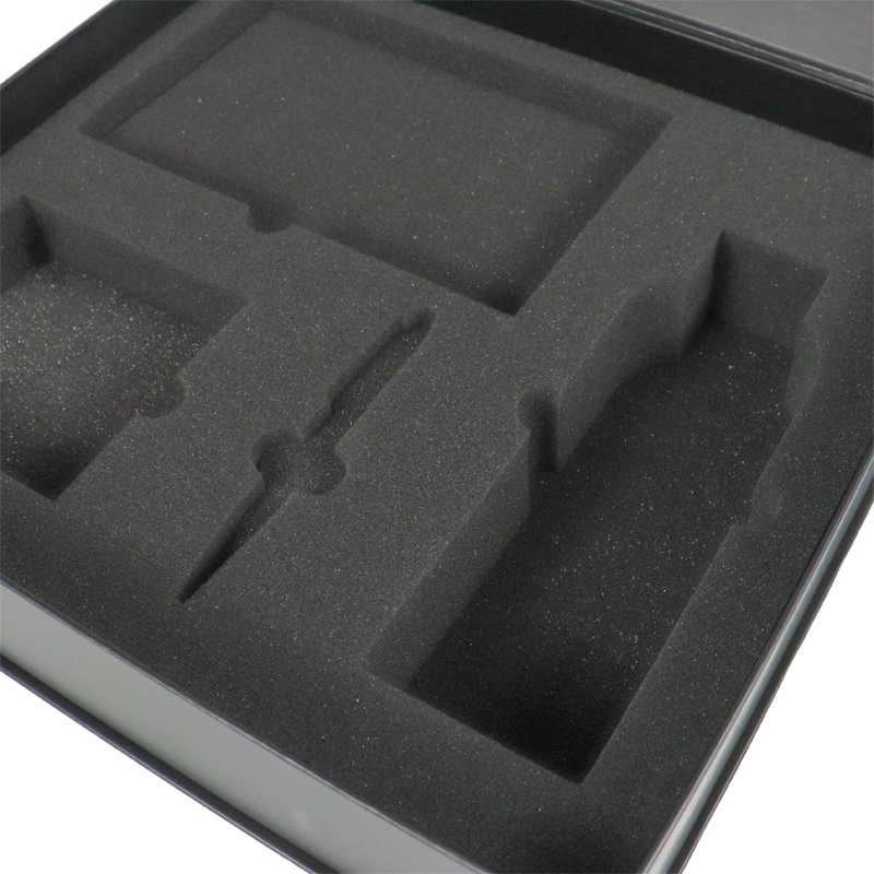 Black EVA foam insert with custom cavities for multiple items, showcasing precision protection in luxury apparel packaging.