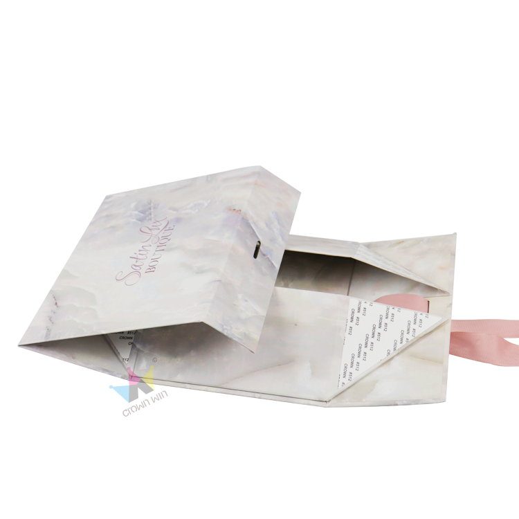 Comparison of a closed book-style rigid box labeled “CLOUD ATLAS” next to an unfolded, map-printed folding carton—highlighting structural differences between premium rigid boxes and economical folding cartons for clothing packaging.