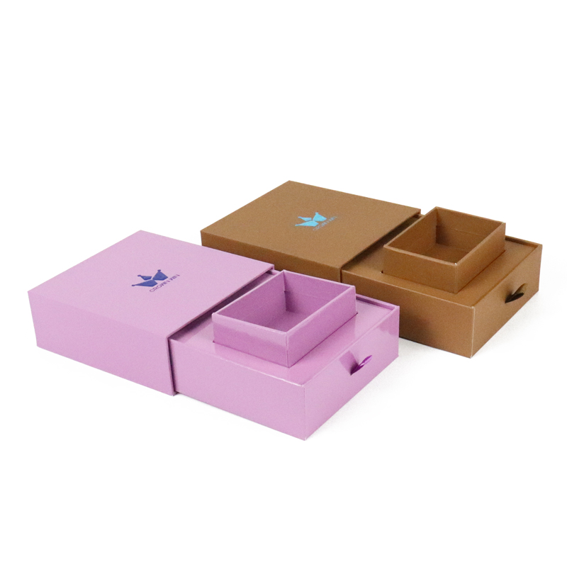 Two elegant drawer-style rigid boxes in lavender and kraft brown, featuring internal compartments and branded logos—designed for premium apparel or accessories to enhance presentation and support a layered unboxing experience.