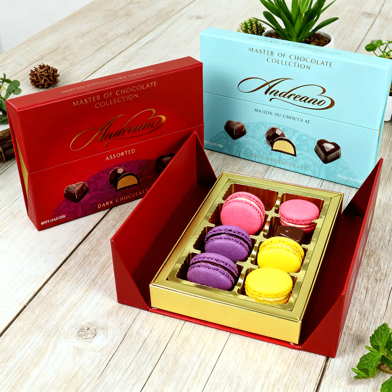 Red and blue chocolate gift boxes with gold foil accents and vibrant macarons, showcasing premium packaging printed using Pantone spot colors for accurate brand color reproduction and high-end appeal.