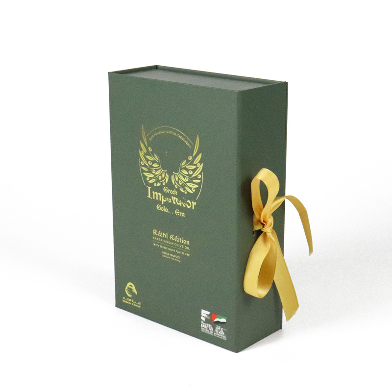 Green rigid gift box featuring a gold foil emblem with wings and text, tied with a golden ribbon, presented against a white background.