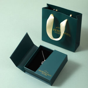 Luxury jewelry packaging boxes with rigid construction and matching branded gift bag for premium necklace presentation