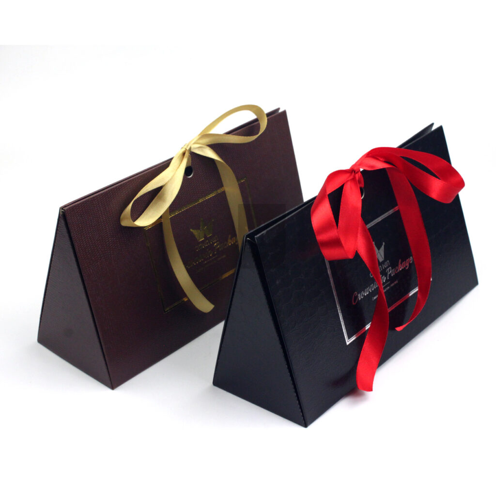Brown and black pyramid-shaped gift boxes with textured finishes and decorative satin ribbons, designed for high-end fashion accessories, skincare, or limited-edition clothing collections.