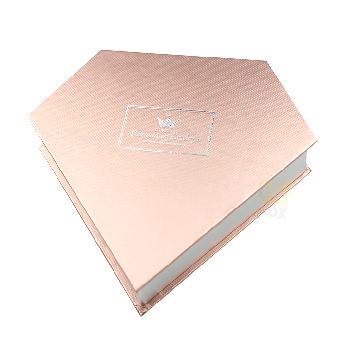 Rose gold rigid box with subtle textured surface and silver foil logo, showcasing soft touch lamination for a luxurious, tactile feel in high-end gift packaging.