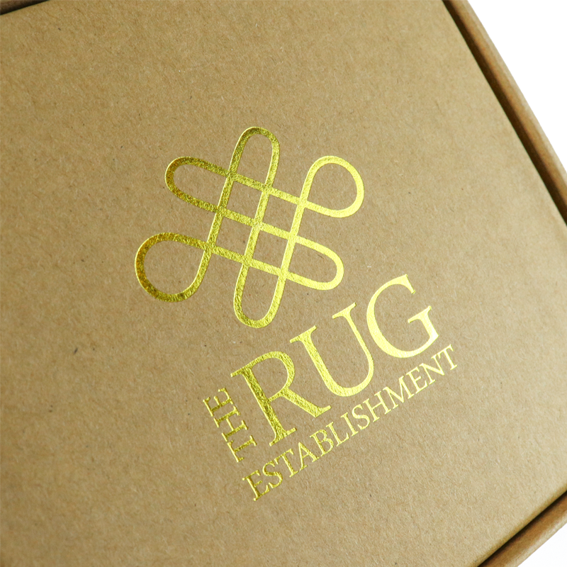 Close-up of a gold foil-stamped logo on a natural kraft paper box—highlighting sustainable luxury packaging that combines eco-friendly materials with high-end finishing techniques like metallic stamping.