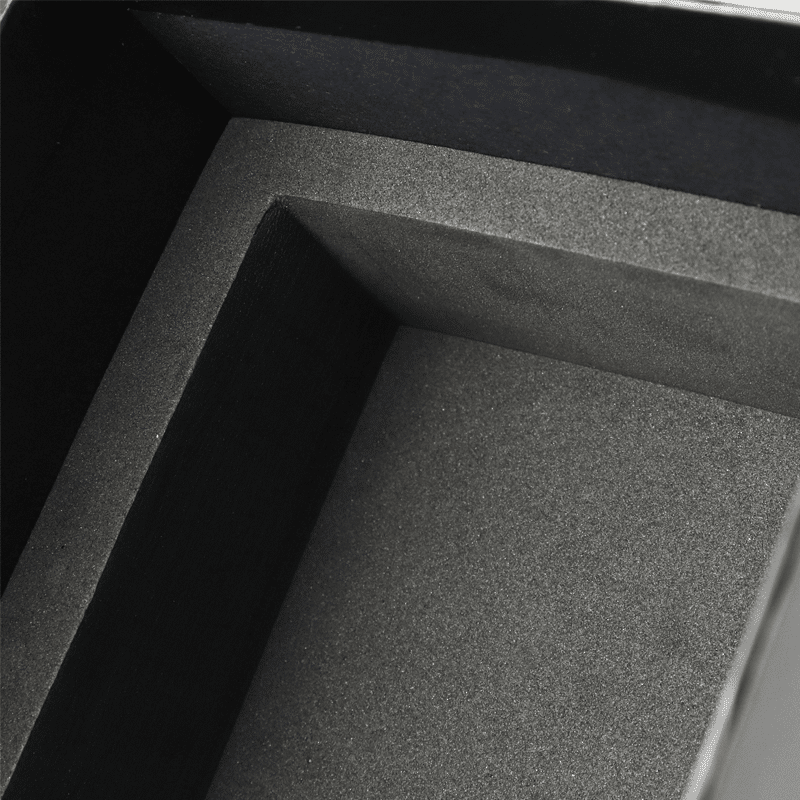 Close-up view of a black EVA foam insert inside a rigid wine box, showing its dense texture and precise fit around the bottle cavity.