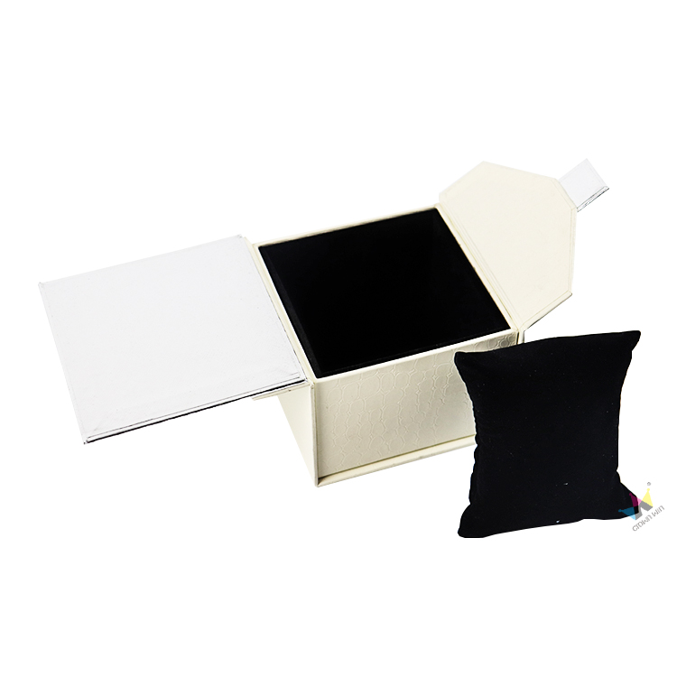 Open white rigid jewelry box with textured surface and black velvet lining, featuring a detachable cushioned pillow, showcasing durable and protective custom packaging design.