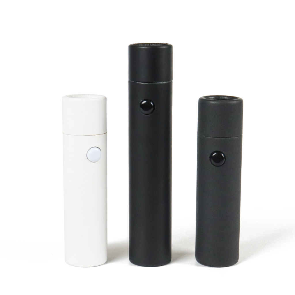 Three cylindrical vape cartridges in white and black finishes, featuring button controls and sealed caps, displayed against a clean white background.