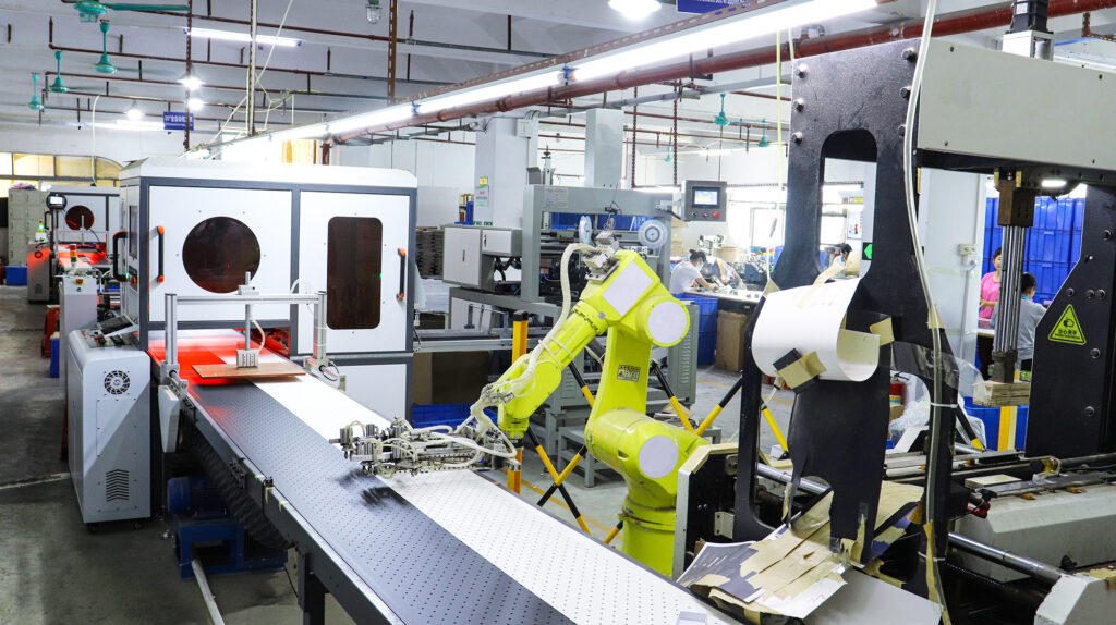 Industrial automation in custom watch packaging manufacturing, featuring robotic arms and high-speed printing machines—critical for managing lead time and quality control.