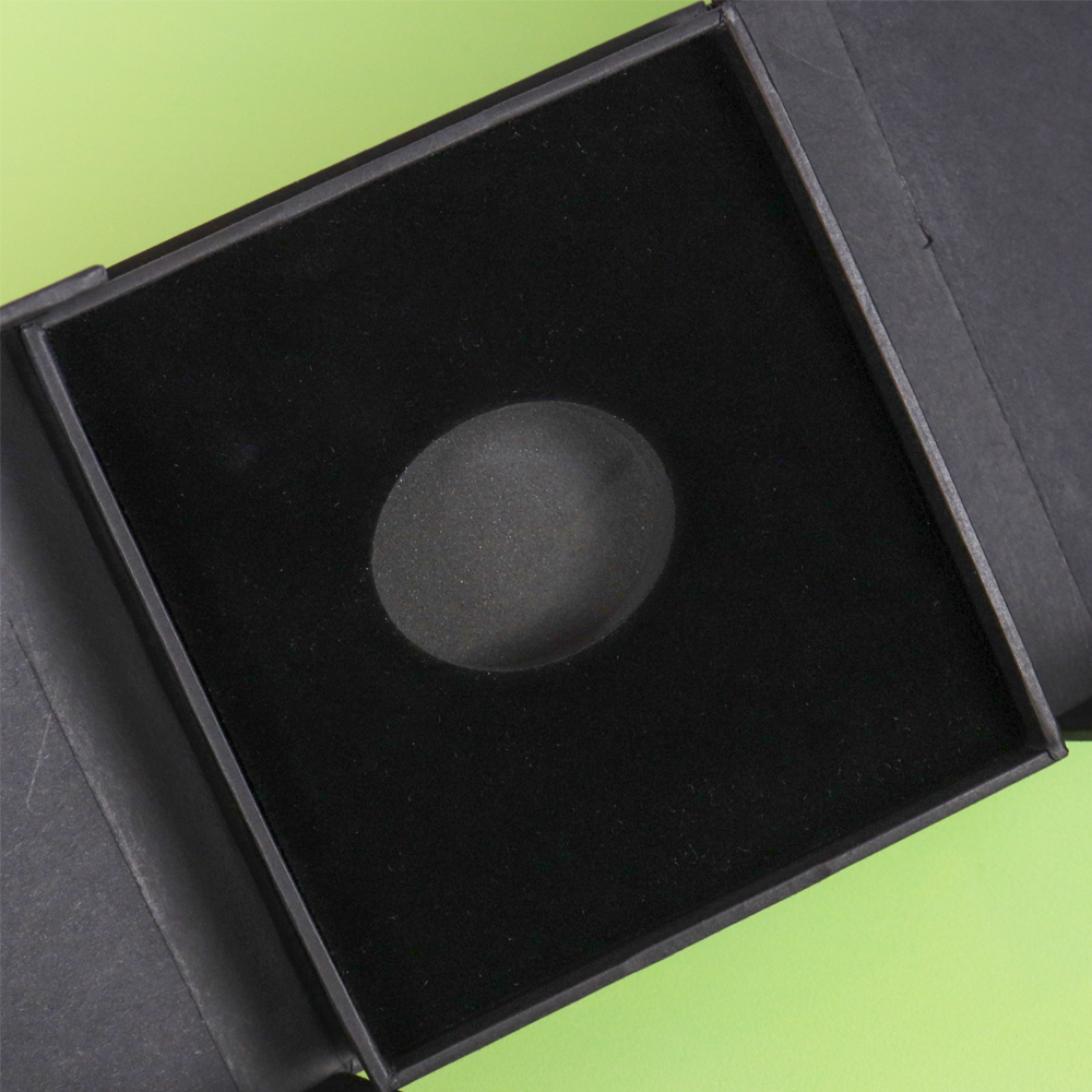 Open black box with soft velvet interior and a central circular cutout, designed to hold a ring or pendant securely.
