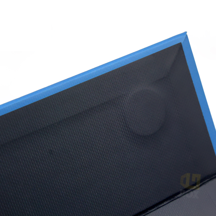 Close-up view of a high-strength rigid box corner featuring reinforced blue edges and textured black interior, demonstrating structural integrity critical for child-resistant vape packaging compliance.