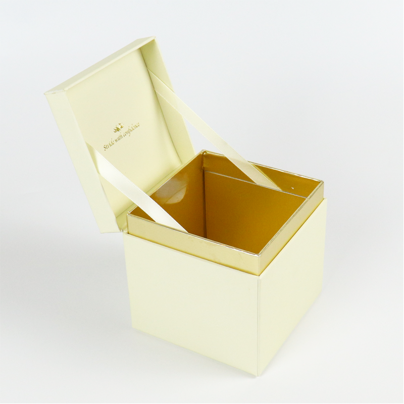 Open cream-colored box with gold interior lining and satin ribbon closure, featuring gold foil text "Stride with confidence" on inner lid.