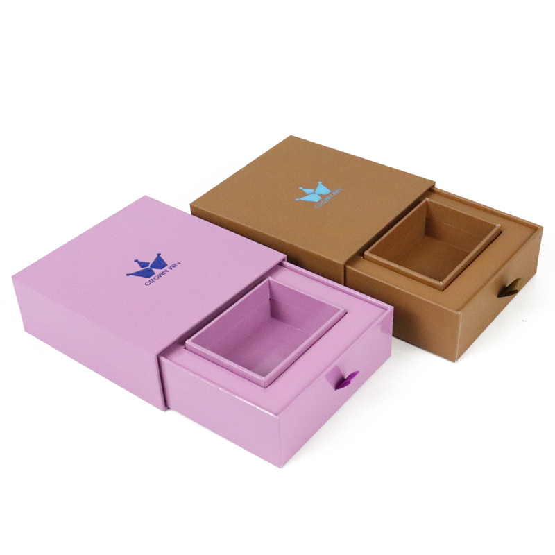 Two open drawer-style jewelry boxes in purple and brown, each featuring a branded crown logo and nested inner tray.