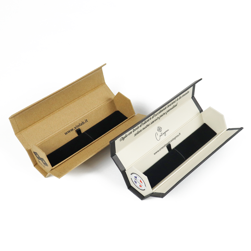 Two open elongated boxes in kraft and white finishes with black foam inserts and printed internal panels, illustrating how fold design affects label positioning and durability.