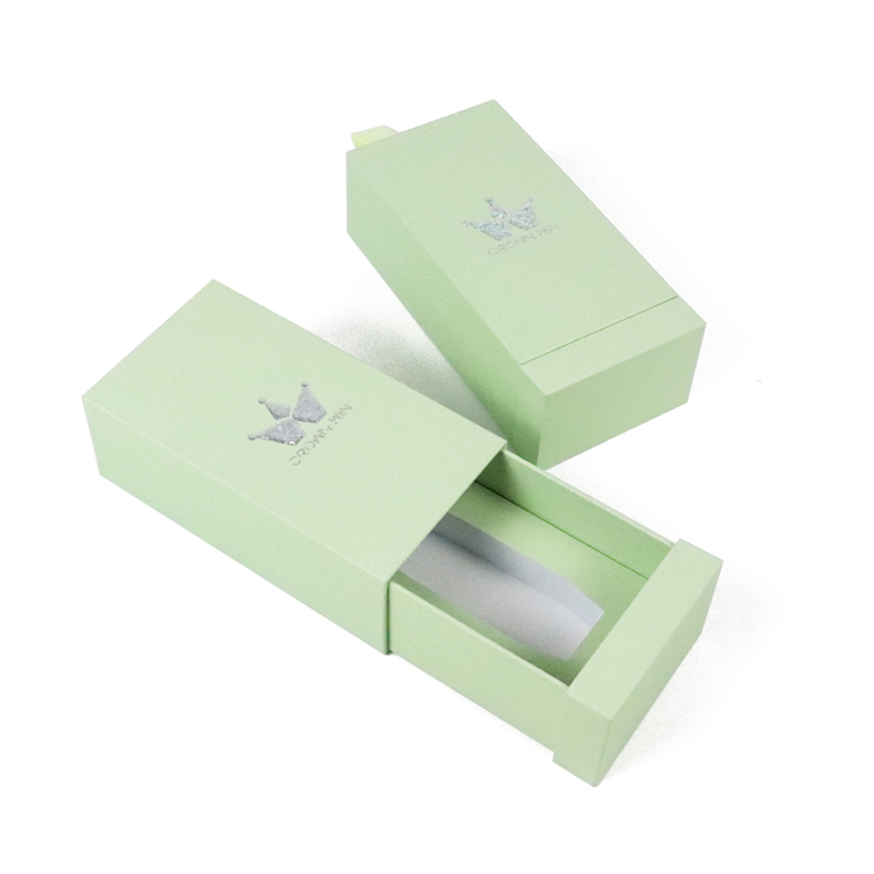 Light green drawer box with silver foil crown logo and partial transparent window, designed for premium presentation and controlled access.