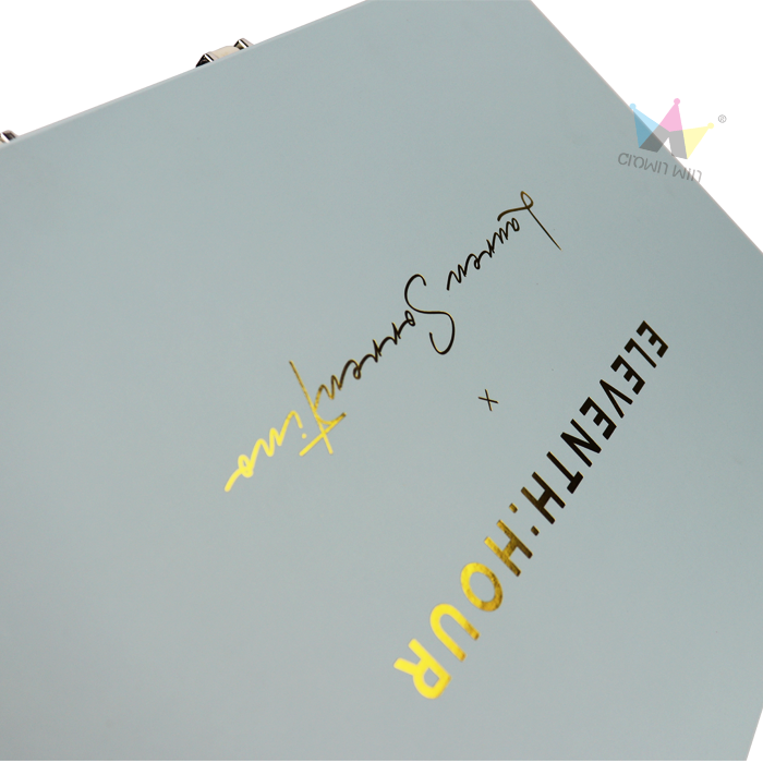 Light blue box lid with dual-tone foil stamping: gold text "ELEVENTH:HOUR" and black cursive signature "Lauren Sorensen", showcasing artistic branding.