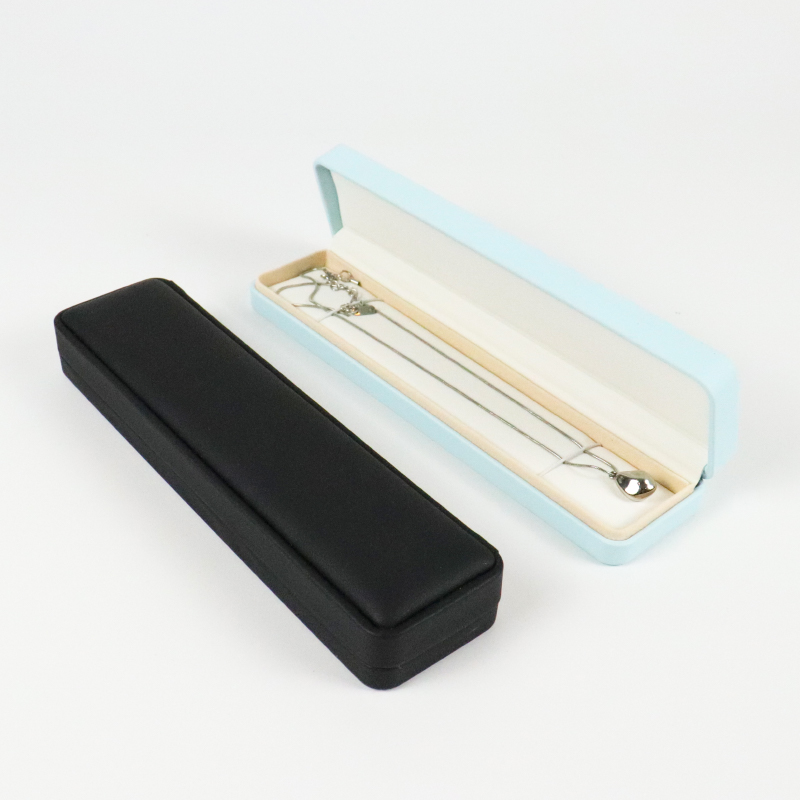 Light blue jewelry box open to reveal a silver chain neatly laid in a soft-lined channel, designed to prevent tangling during transport.
