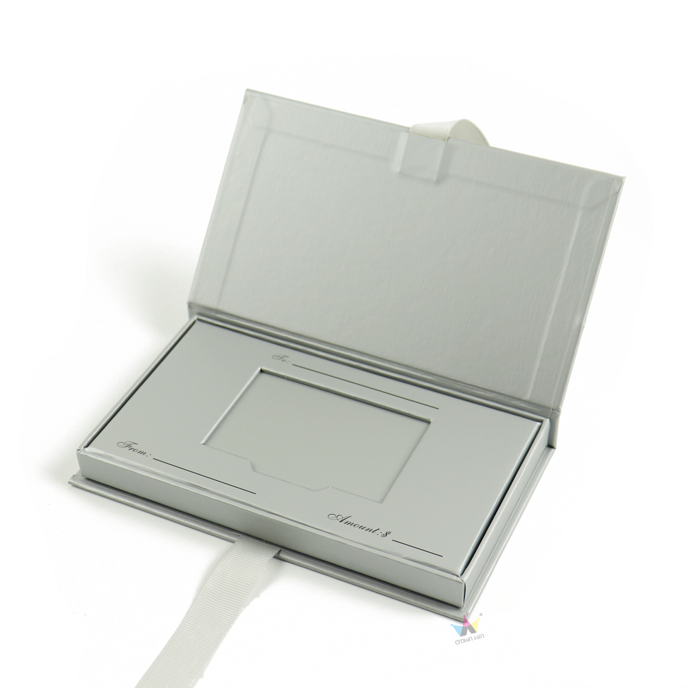 Open silver rigid box featuring a built-in envelope insert with "To:", "From:", and "Amount $ " fields, secured by a white ribbon.