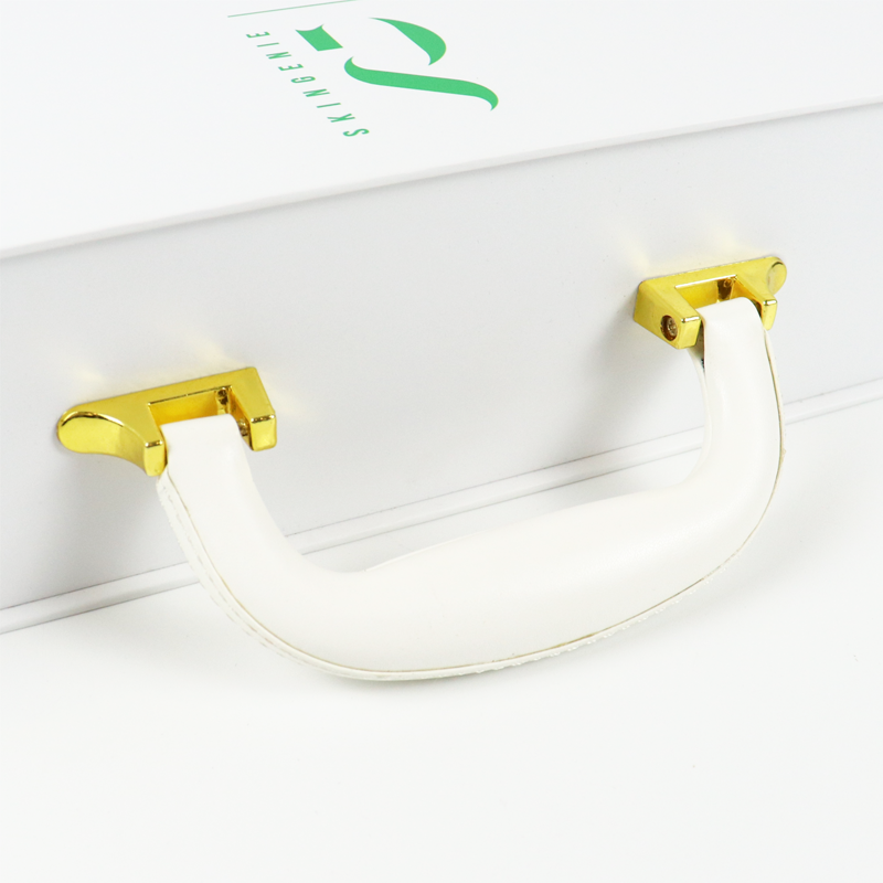 Close-up of a white rigid box featuring a gold metal handle and green foil-stamped logo "SKINGEMIE", showcasing premium hardware integration.