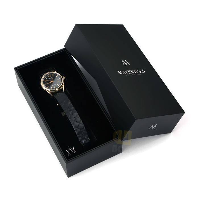 Sleek black watch box with minimalist branding and velvet-lined interior, showcasing a gold-tone watch with black textured strap—ideal for modern luxury brands.