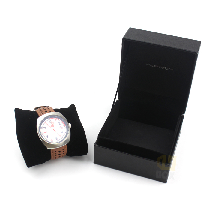 Open black watch box featuring a velvet cushioned pillow insert holding a wristwatch, designed to prevent movement during transit and storage.