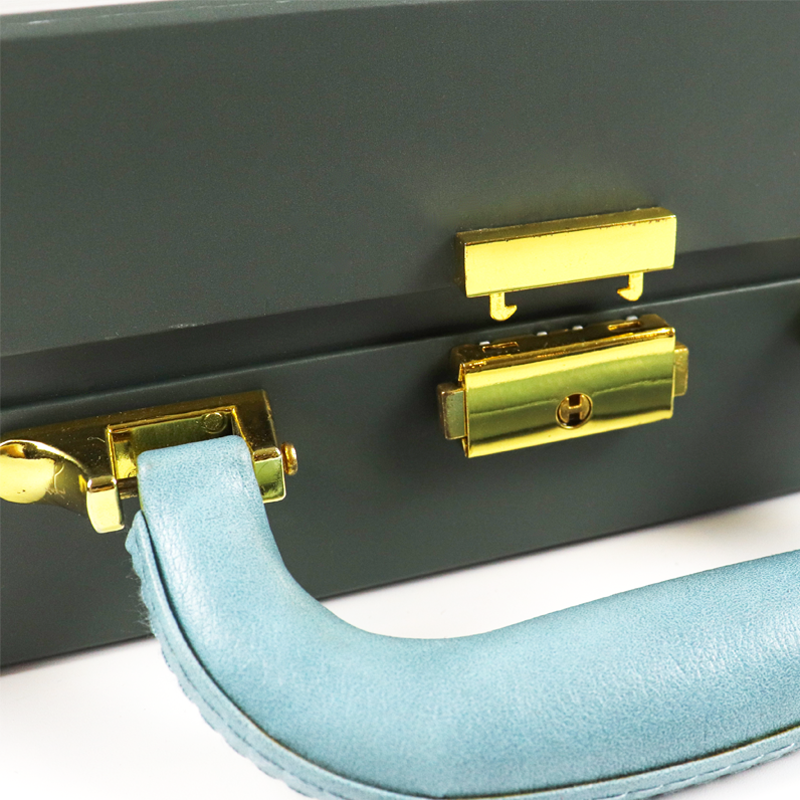 Close-up of gold metal clasp and blue leather handle on a premium packaging case, highlighting a robust locking mechanism designed to prevent unauthorized access.