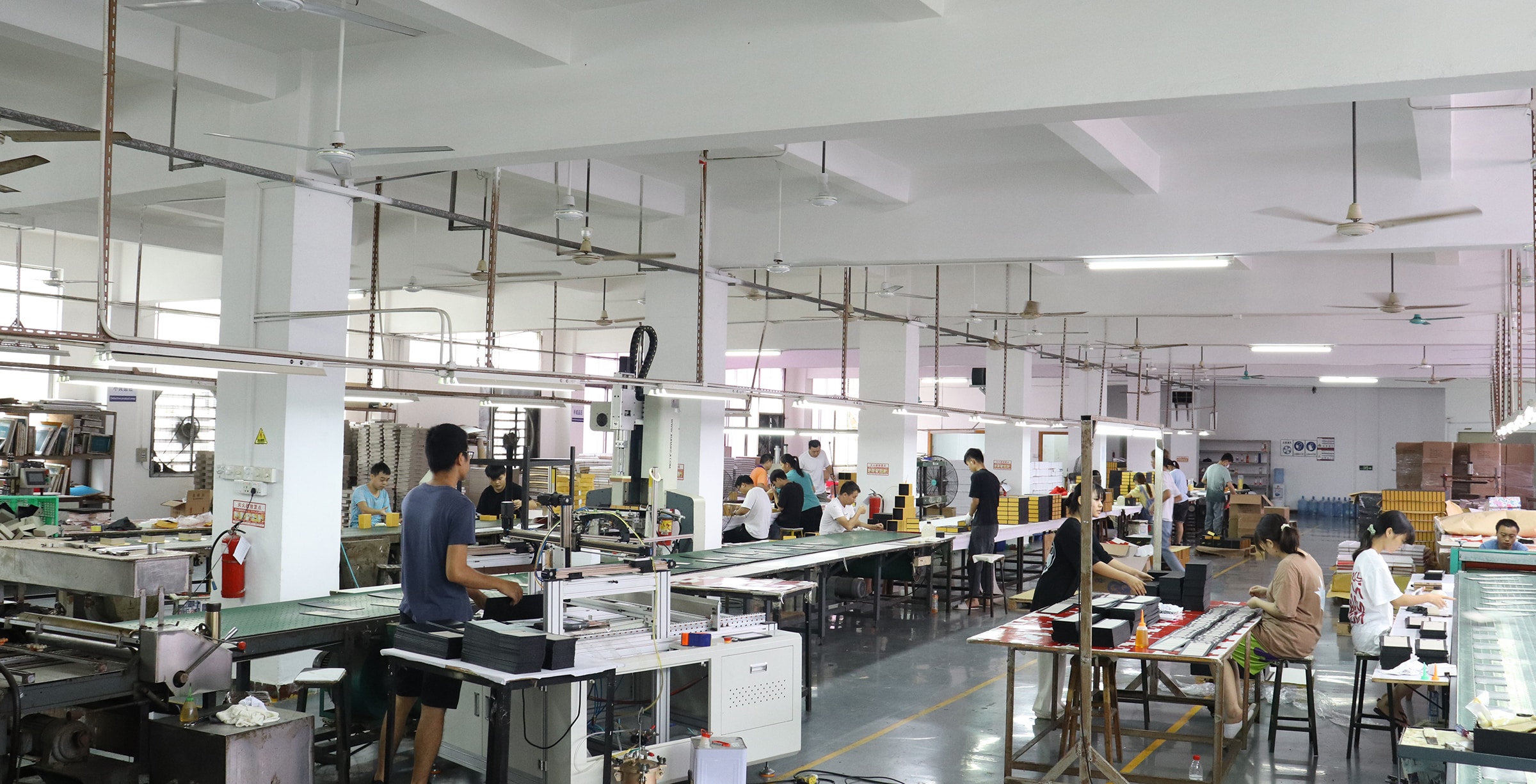 Custom paper packaging factory workshop with workers assembling, finishing and inspecting luxury rigid boxes for OEM packaging production and global brands.