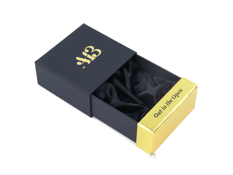 Custom black slide-out drawer gift box with gold foil logo, metallic gold pull tab and black satin insert for luxury jewelry, cosmetics and premium gift packaging.
