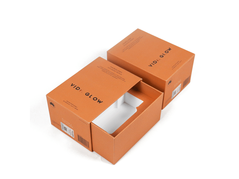 Custom orange slide-out drawer packaging box with printed branding and white protective insert, designed for cosmetics, skincare products and beauty gift packaging.